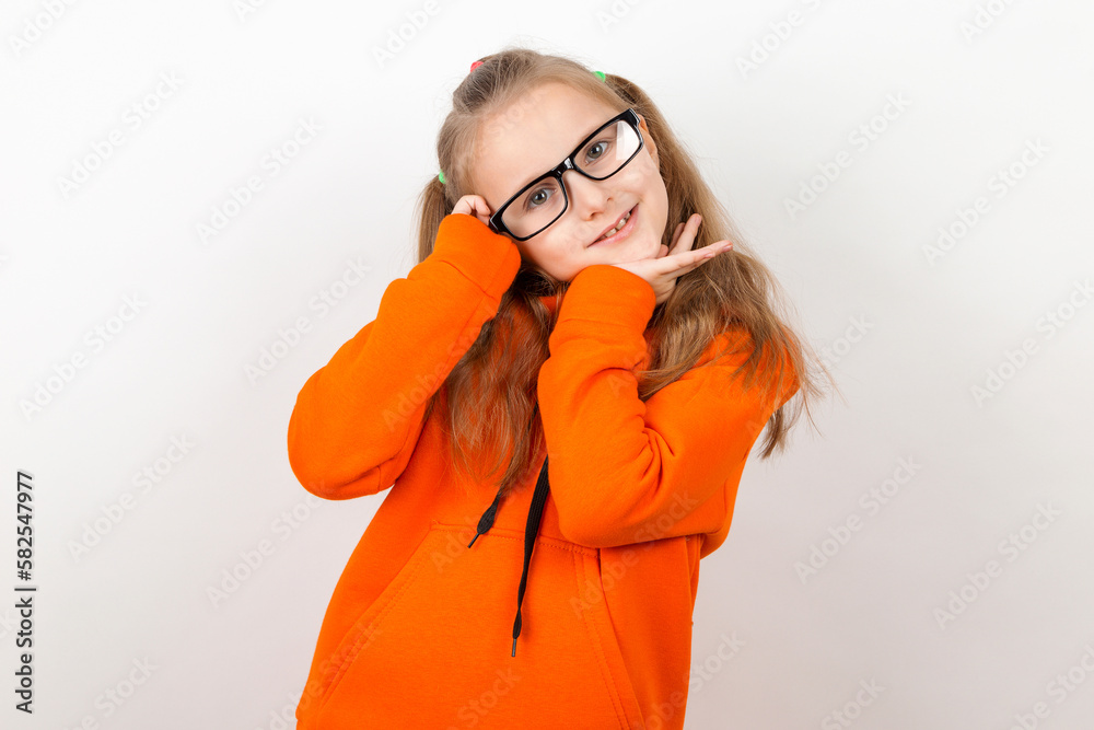 Canvas Prints A little girl in an orange suit and eyeglasses. Emotions, a portrait on a white background.