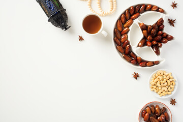 Ramadan Kareem banner with dried dates in Islamic star and crescent bowl, lantern, rosary on white background.