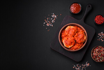 Delicious fresh cutlets or meatballs with spices, herbs and tomato sauce
