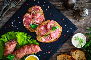 Sliced traditional Polish sausage kielbasa on bread with leafy greens