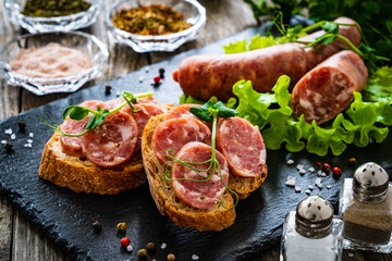 Sliced traditional Polish sausage kielbasa on bread with leafy greens