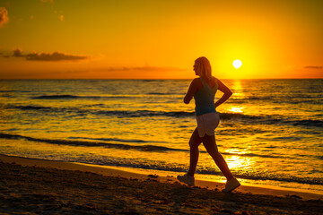 Fototapeta na wymiar Beach holiday - beautiful woman walking, running on sunny, tropical beach in the morning 