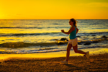 Beach holiday - beautiful woman walking, running on sunny, tropical beach in the morning
