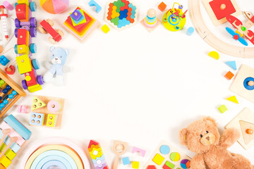 Fototapeta na wymiar Baby kids toy background. Teddy bear, plush, wooden educational, musical, sensory, sorting and stacking toys, train, colorful building blocks on white background. Montessori toys. Top view, flat lay