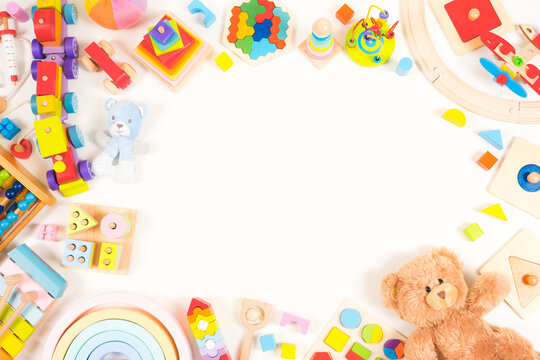 Baby kids toy background. Teddy bear, plush, wooden educational, musical, sensory, sorting and stacking toys, train, colorful building blocks on white background. Montessori toys. Top view, flat lay