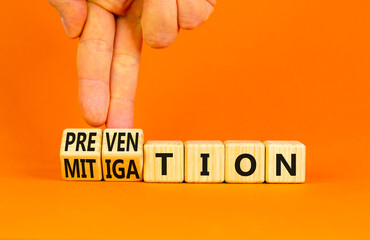 Prevention or mitigation symbol. Businessman turns cubes and changes the concept word Mitigation to...