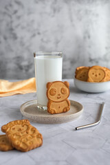 Funny children's cookies in the form of animals and a glass of milk on a gray marble table. Baby food. Baking for children.