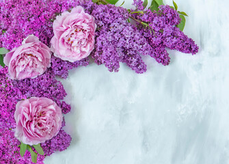 Peonies and lilacs on a light background with putty effect. Top view flat. Frame,