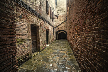 Narrow alley surrounded by stone walls in Buonconvento