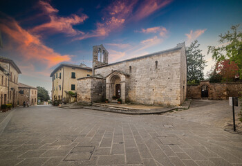 Church in San Quirico d'Orcia under a colorful sky at sunset