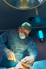 surgeon in the operating room is standing at the table with the patient under the lamp