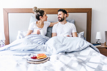 latin couple having breakfast in bed at home in Mexico, hispanic people