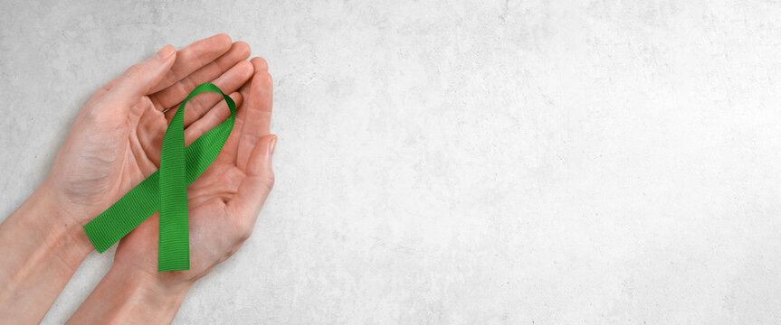 Green Ribbon in Woman's Hands, Mental Health, Glaucoma Awareness with Copy Space