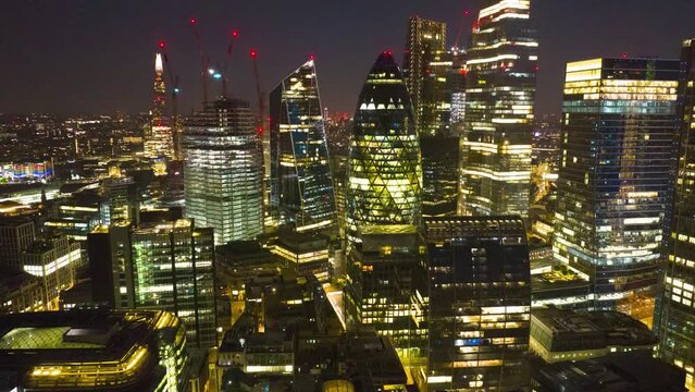 Amazing night scene of illuminated downtown skyscrapers. Hyperlapse shot of modern high rise business buildings in City borough. London, UK