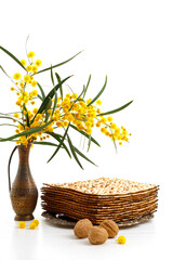 Jewish holiday Pesach (Passover). Matzah, Acacia dealbata flowers, walnuts and other attributes of the holiday on white background.