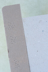 Fototapeta premium cardboard stripe with small puncture holes on a neutral background