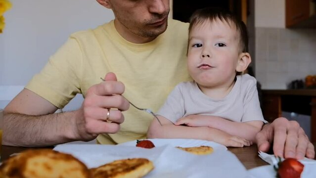 dad feeding baby with pancake fork