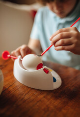 Boy painting Easter eggs