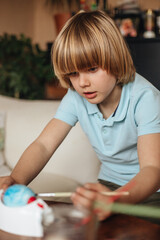 Boy painting Easter eggs