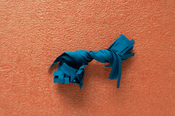 twisted paper object on orange paper texture