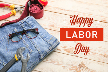 Greeting card for Labor Day with jeans, tools and eyeglasses on white wooden background