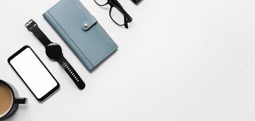 Modern mobile phone with smart watch, wallet, eyeglasses and cup of coffee on light background with space for text