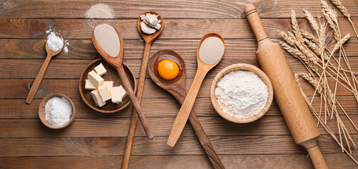 Fototapeta na wymiar Ingredients for dough and rolling pin on wooden background
