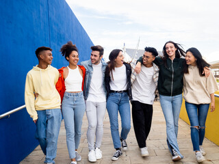 Group of diverse teenagers walking and having fun in a city.