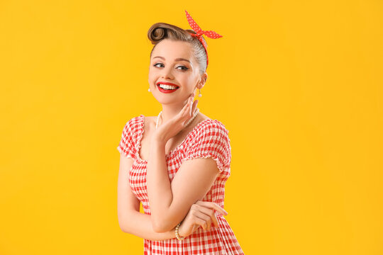Young pin-up woman on yellow background