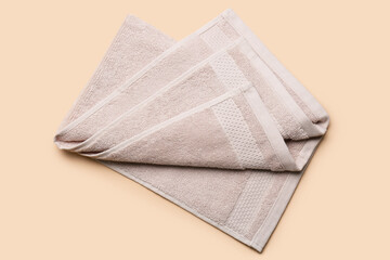 Folded soft towel on beige background