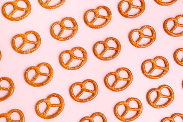 Composition with tasty salted pretzels on pink background - obrazy, fototapety, plakaty