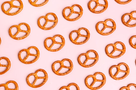 Composition with tasty salted pretzels on pink background