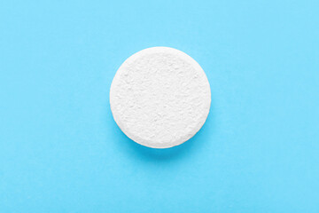 White soluble tablet on blue background