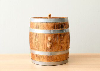 Wooden barrel on table near light wall