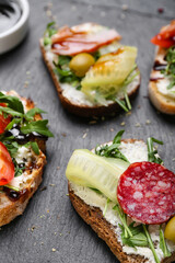 Slate board with tasty sandwiches and sauce, closeup