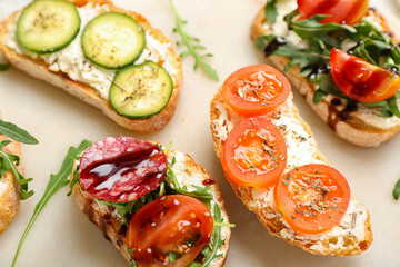 Tasty sandwiches with cream cheese, tomatoes and cucumber on board, closeup