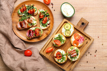 Composition with delicious sandwiches, cream cheese and tomatoes on wooden background