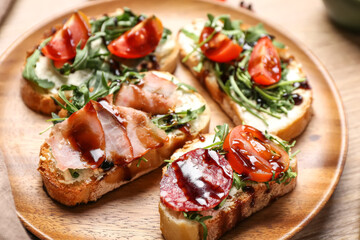 Fototapeta na wymiar Wooden plate with tasty sandwiches, closeup