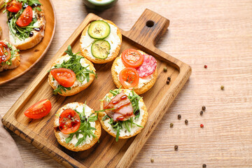 Board with delicious sandwiches on wooden table