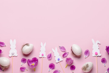 Easter eggs with paper rabbits and tulips on pink background