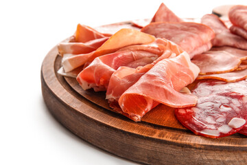 Wooden board with assortment of tasty deli meats isolated on white background, closeup