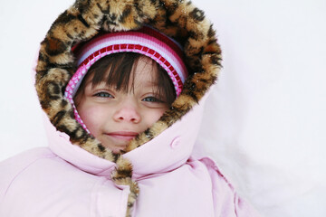 Close up portrait of young girl outside in winter smiling.