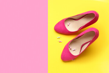 Heels with pins on color background. April Fools' Day celebration