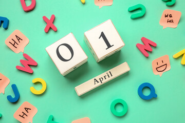 Date of April Fool's Day with letters and sticky papers on color background