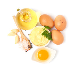 Bowl with tasty mayonnaise sauce and ingredients on white background