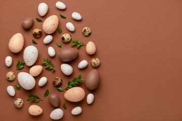 Creative composition with Easter eggs and plant leaves on brown background