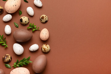 Composition with Easter eggs and plant leaves on brown background