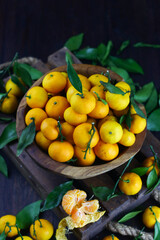 Mandarin orange on rustic wooden bowl and dark wooden background. 