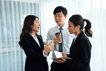 Mentor, manager with coffee advice younger colleagues in workplace. Businesspeople discussing or...
