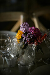 beautiful purple bouquet on farm table at wedding, moody light